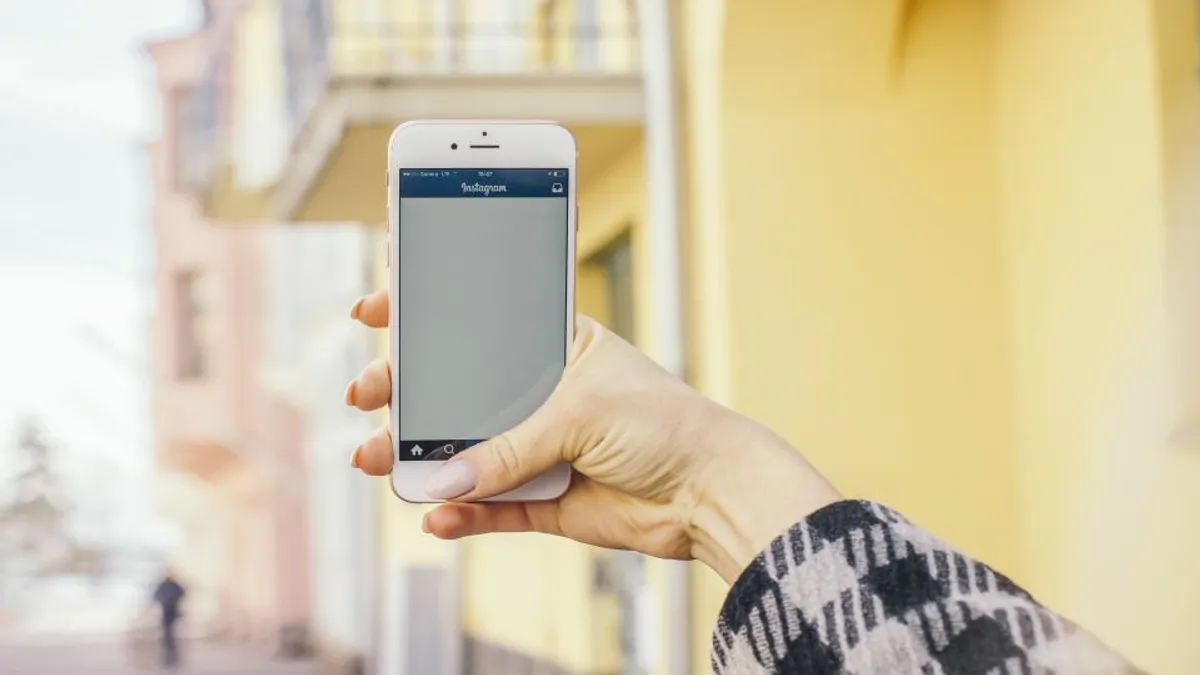 Mão segurando um smartphone com um aplicativo aberto