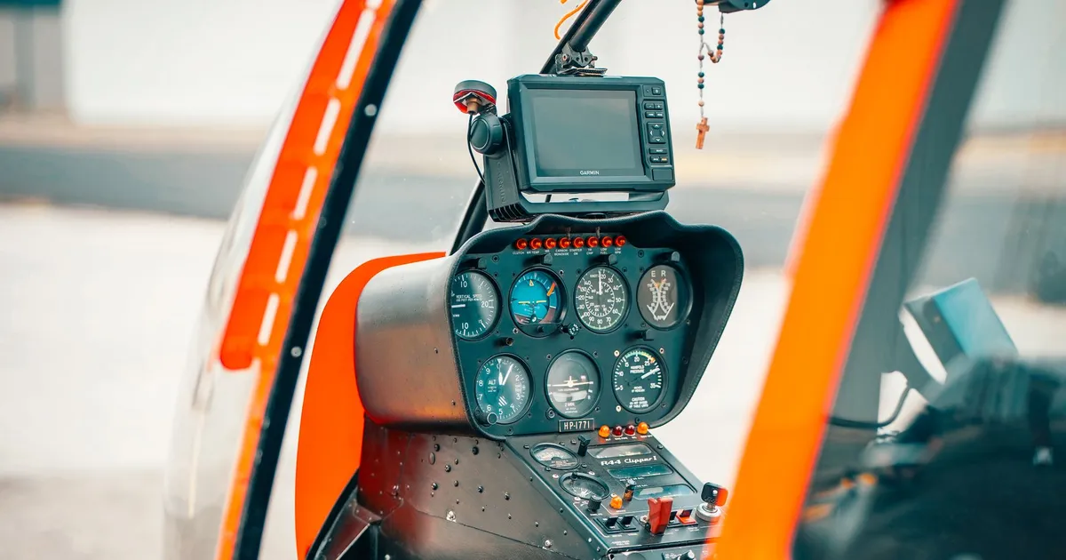 Close-up view of helicopter cockpit display panels, controls, and navigation equipment.