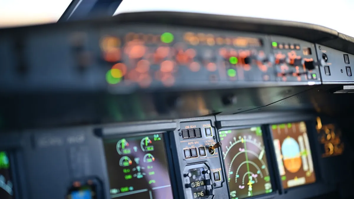 Close-up view of airplane cockpit instrumentation with modern digital displays.