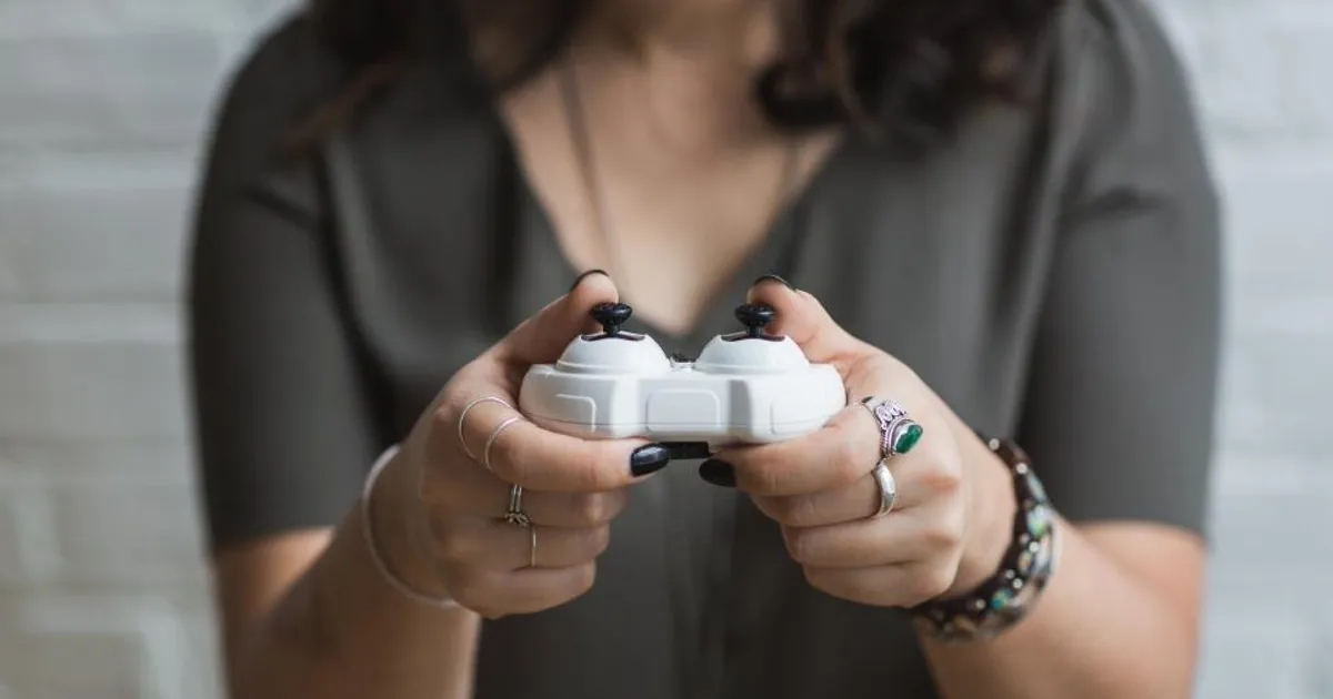 Pessoa segurando um controle de videogame branco