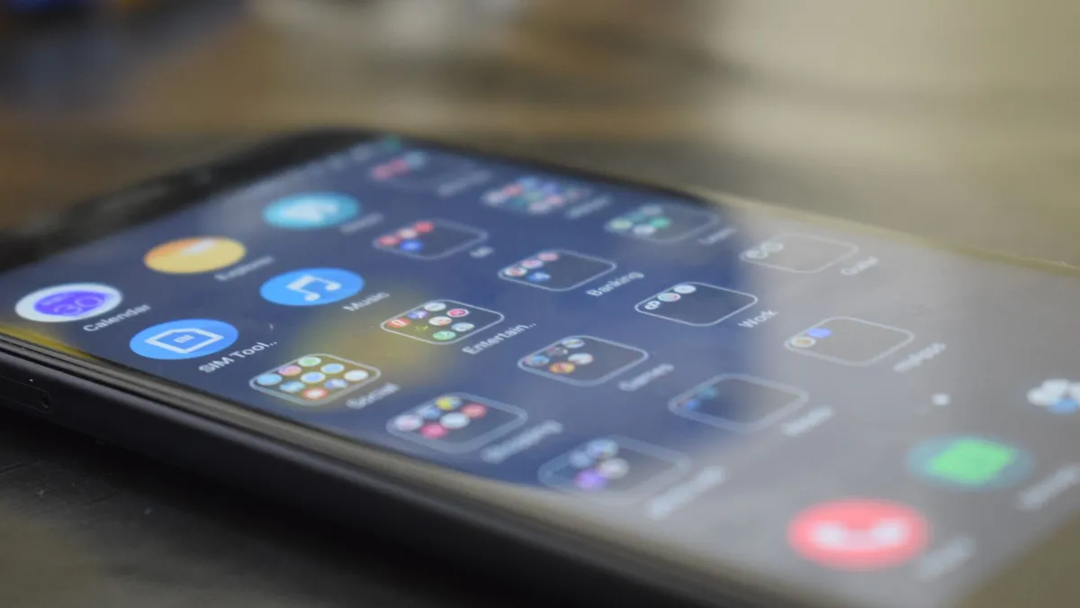 Close-up shot of a smartphone screen showing various app icons, indicating digital technology use.