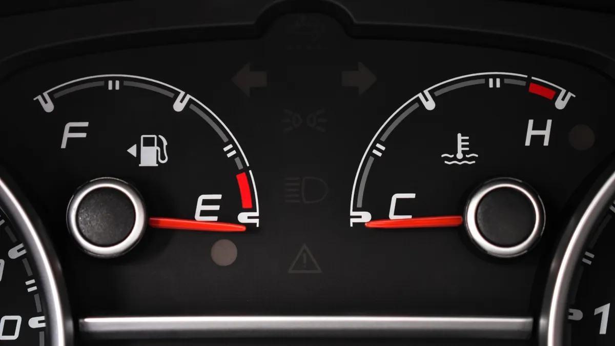 Detailed view of a car's fuel and temperature gauges on dashboard.