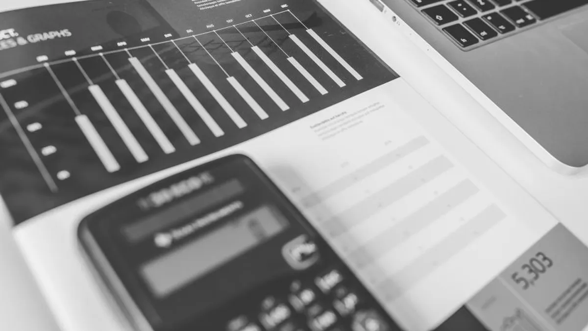 Relatório financeiro impresso com gráficos de barras e calculadora