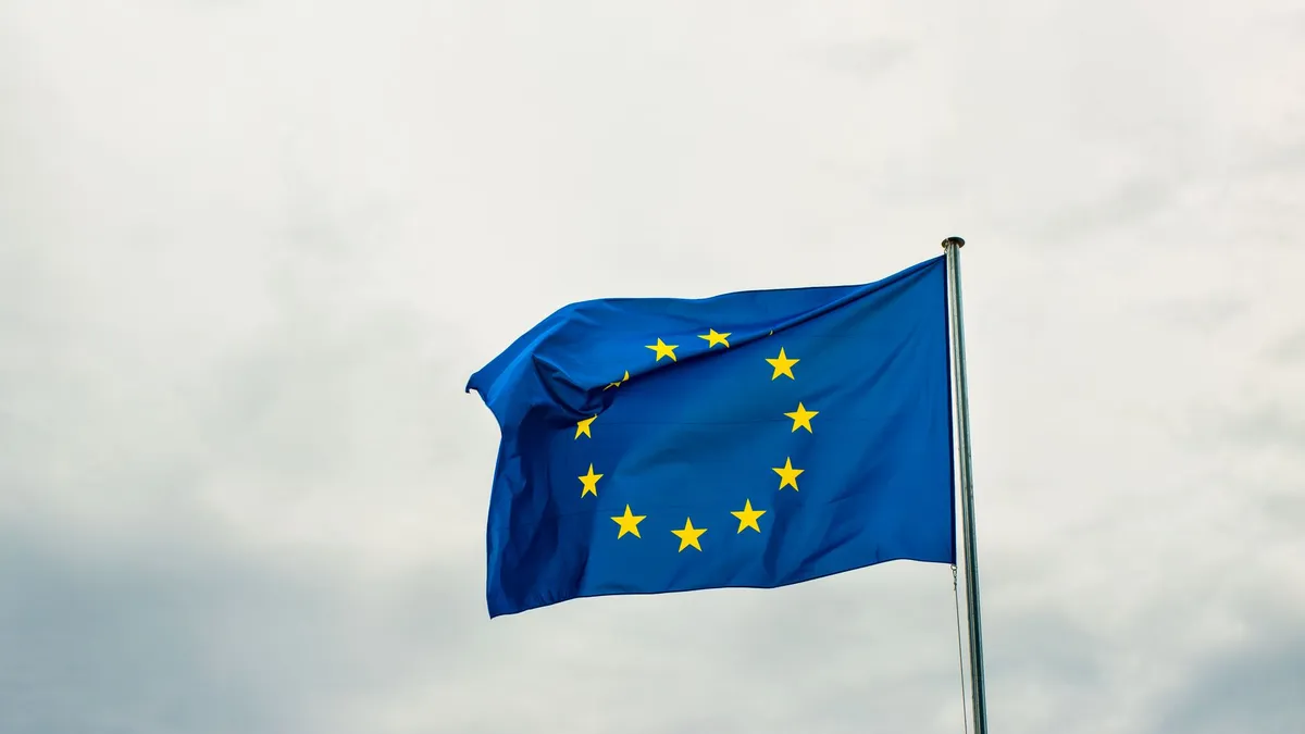 European Union flag waving vividly against a cloudy sky in Strasbourg, France.